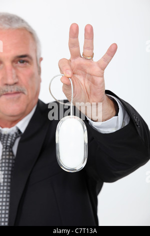 Grigio uomo dai capelli tenendo premuto il mouse del computer Foto Stock