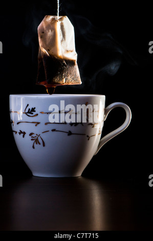 Tazza e un sacchetto da tè su sfondo nero Foto Stock