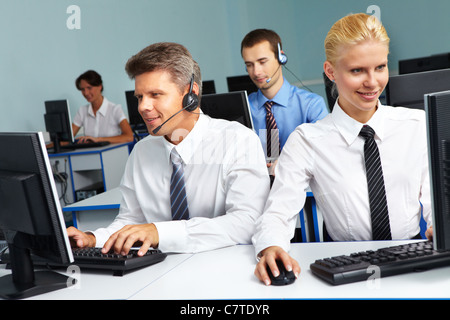 Quattro persone di affari seduto in una stanza e funzionante Foto Stock