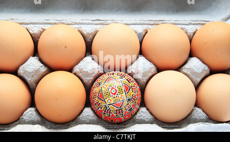 Giallo e rosso pysanka uovo di pasqua in una scatola di cartone di uova di colore marrone Foto Stock