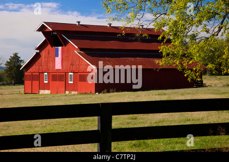 Granaio rosso con bandiera americana vicino a Franklin nel Tennessee USA Foto Stock