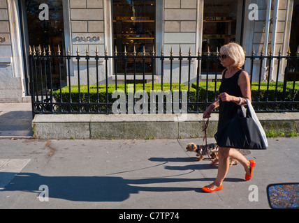 Parigi, Francia, Woman Walking Dog, di fronte al negozio di abbigliamento di lusso, Gucci, shopping su High Street, Avenue Montaigne, gente di strada parigina, autentico stile di vita francese, scarpe di moda di strada soleggiate Foto Stock