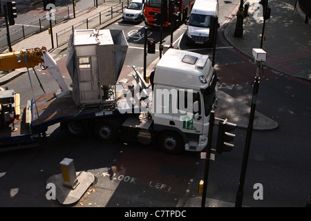 Guardando verso il basso su un autocarro articolato come essa si trasforma in una strada stretta a Londra Foto Stock