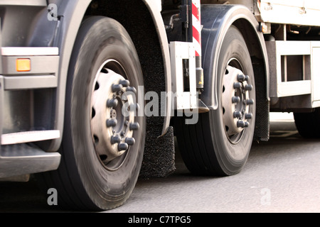 Un basso livello di vista delle ruote anteriori di un camion come viaggiare lungo una strada Foto Stock