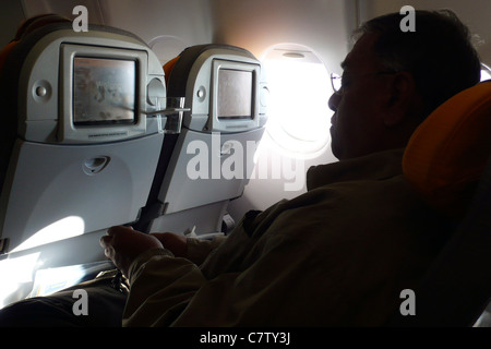 Uomo in aereo durante il volo Foto Stock