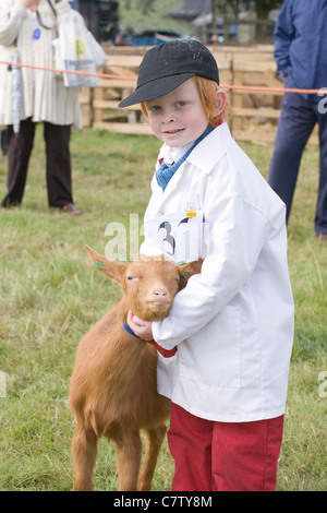 Giovani espositore mostra una Golden Guernsey kid. Aylsham spettacolo agricolo, Norfolk. Foto Stock