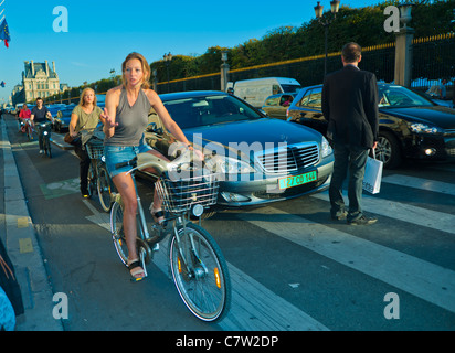 Parigi, Francia, People Cycling on 'Rue de Rivoli', quartiere parigino affollato con Traffic Jam affollato, donne in bicicletta all'aperto, auto, Sunny Day, Streets of Paris, centro città, vivaci biciclette, biciclette e auto a Parigi Foto Stock