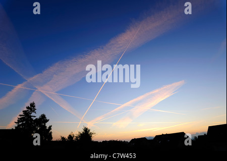 Un criss-cross di jet contrails nelle prime ore del mattino cielo Foto Stock