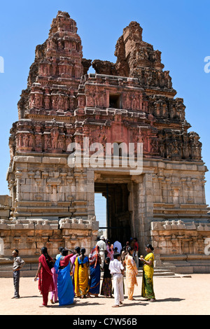 Visitatori indiano all'ingresso del tempio Vittala. Hampi. Il Karnataka. India Foto Stock