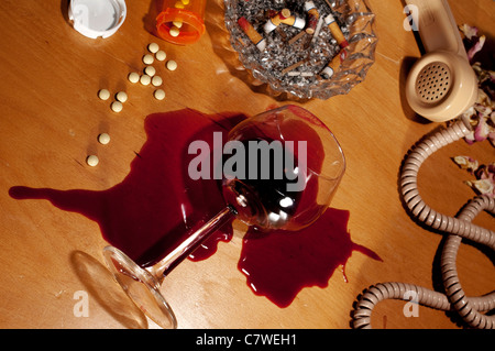 Vino fuoriuscito e pillole sul comodino retrò. Foto Stock