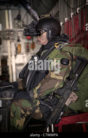 Stati Uniti Navy Seal subacqueo di combattimento equipaggiato con visione notturna si prepara per HALO operazioni di salto da un C-130 Hercules. Foto Stock