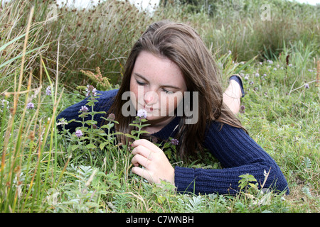 Ragazza in un prato; Marazion; Cornovaglia; con acqua menta Foto Stock