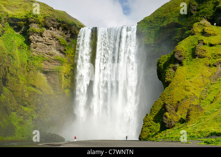 I turisti alla cascata Skogar nel sud-ovest dell'Islanda. Foto Stock