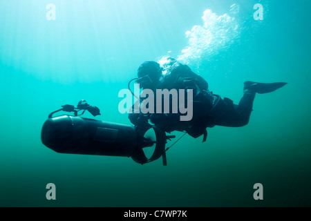 Forze per le operazioni speciali combattere diver naviga in acque utilizzando un subacqueo del veicolo a propulsione. Foto Stock