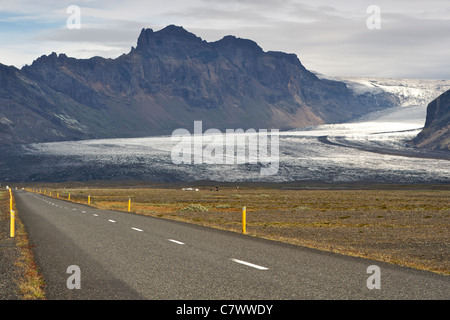 Vista della Corona islandese strada che conduce a Skaftafell National Park e il ghiacciaio Skaftafellsjokull nel sud-est dell'Islanda. Foto Stock