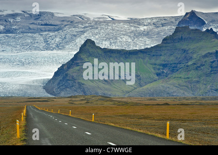 La corona islandese su strada e piste di Islanda la montagna più alta della Hvannadalshnúkur (2110m), parte del ghiacciaio Oraefajokull. Foto Stock