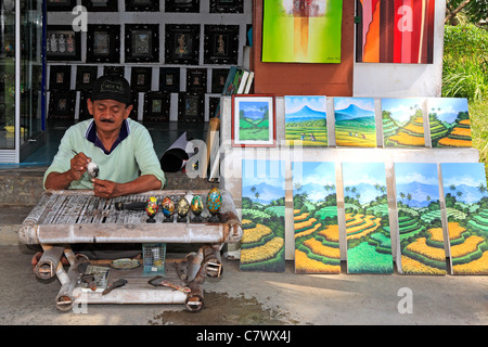 Artista Wayan Rana, pittura delle uova, al di fuori del suo negozio nel villaggio Sebali, nei pressi di Ubud. Bali, Indonesia. Modello rilasciato Foto Stock