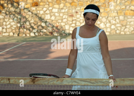 Deluso giocatore di tennis donna holding racket e guardando verso il basso Foto Stock