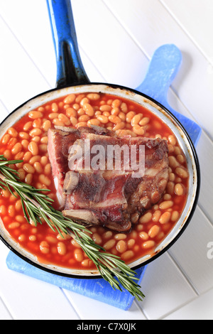 Fumato costolette di maiale con fagioli al forno in un tegame Foto Stock