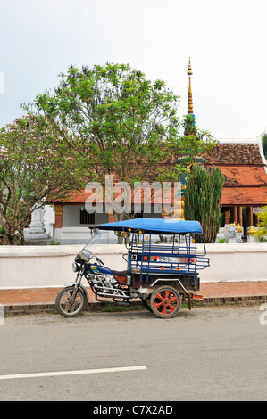 Tuk tuks sono una visione comune nella storica città di Luang Prabang, inserito dall'UNESCO nella lista del patrimonio mondiale il centro città in Laos. Foto Stock