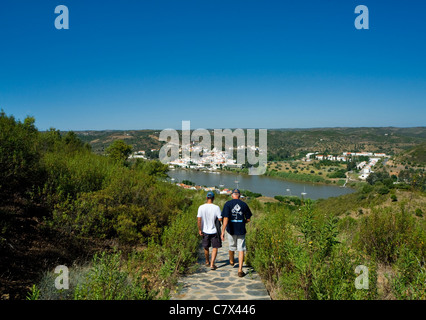 I turisti a piedi vicino al castello a Sanlúcar del Guadiana in Andalusia, Spagna Con Alcoutim, Portogallo in background Foto Stock