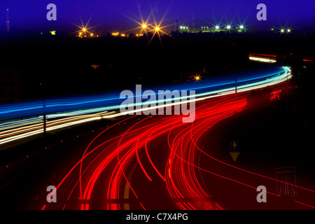 Auto sentieri di luce in bianco e rosso su strada di notte la curva Foto Stock