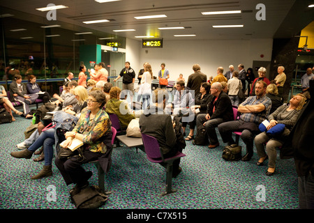 La folla dei passeggeri del trasporto aereo in attesa presso il cancello per il loro volo, la partenza lounge, l'Aeroporto Changi di Singapore Asia Foto Stock