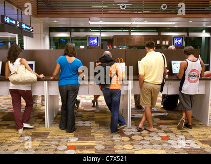 I passeggeri del trasporto aereo che utilizzano il computer nella sala partenze, l'Aeroporto Changi di Singapore asia Foto Stock