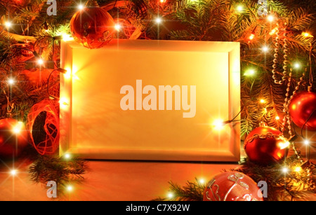 Colorato sfondo astratto con le luci di Natale e cornice bianca. Sfondo di natale con nastro boll e ornamenti Foto Stock
