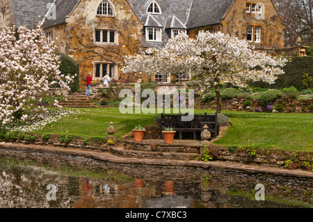 Gli ospiti godono i tranquilli giardini di Coton Manor in primavera, Coton, Northamptonshire, Inghilterra per solo uso editoriale Foto Stock