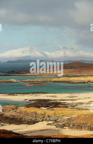 Sanna Bay, Isola di Muck e coperta di neve Isola di rum in distanza, vista da Portuaik a Sanna passeggiata costiera, a Ardnamurchan Foto Stock