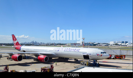 Una volta che la più lunga del mondo aereo di linea: la slanciata Virgin Atlantic Airbus A340 in piano sul terreno al terminal di un aeroporto Foto Stock