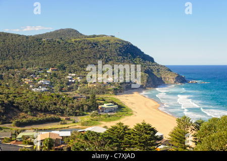 Piccola città accanto a un idilliaco rural surf beach in una baia riparata tra colline boscose. Foto Stock