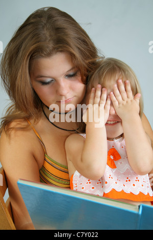 Due sorelle differenti età di leggere il libro di grandi dimensioni Foto Stock