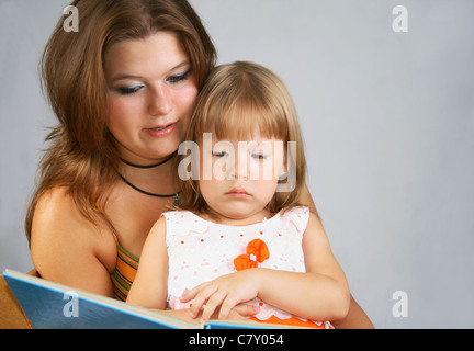 Due sorelle differenti età di leggere il libro di grandi dimensioni Foto Stock