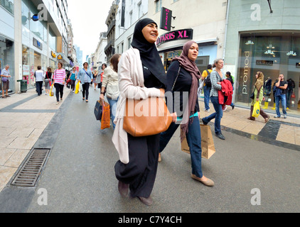 Bruxelles, Belgio. Due donne in velo camminando per strada per lo shopping Foto Stock