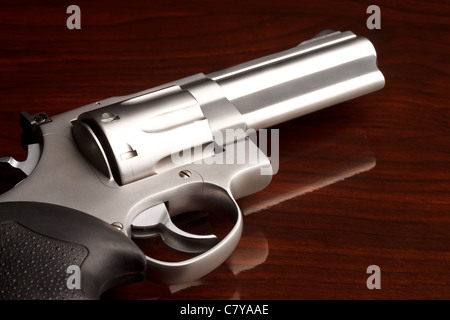 Close-up shot di .357 revolver riflettente sulla superficie di legno Foto Stock
