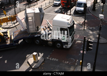 Guardando verso il basso su un autocarro articolato come essa si trasforma in una strada stretta a Londra Foto Stock