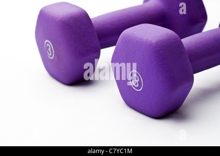 Una coppia di 3 lb viola i pesi in neoprene accanto a ogni altro su di una superficie bianca Foto Stock