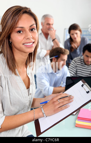 Donna con Blocco note in aula Foto Stock