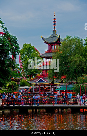 Ponte sul Dragon Boat lago del parco divertimenti Giardini di Tivoli con pagoda e montagne russe Foto Stock