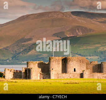 Beaumaris Castle sostenuta da Snowdonia, Beaumaris, Anglesey, Galles del Nord, Regno Unito Foto Stock