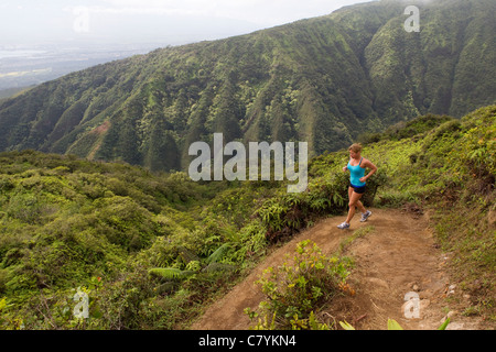 Una donna in esecuzione sul crinale Waihee Trail a Maui. Foto Stock