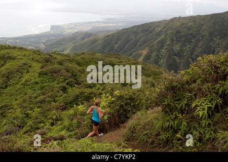 Una donna in esecuzione sul crinale Waihee Trail a Maui. Foto Stock