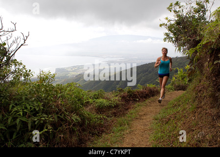 Una donna in esecuzione sul crinale Waihee Trail a Maui. Foto Stock