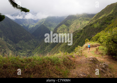 Una donna in esecuzione sul crinale Waihee Trail a Maui. Foto Stock