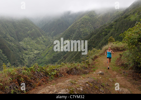 Una donna in esecuzione sul crinale Waihee Trail a Maui. Foto Stock