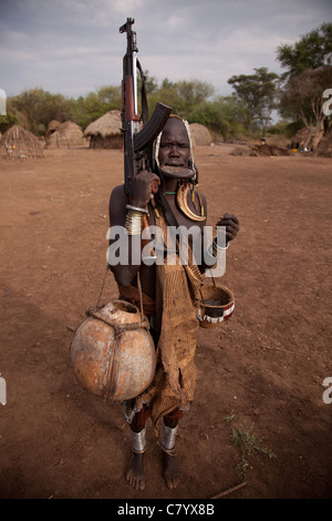 Mursi donna con disco a labbro e AK47, Jinka, Valle dell'Omo, Etiopia, Africa Foto Stock