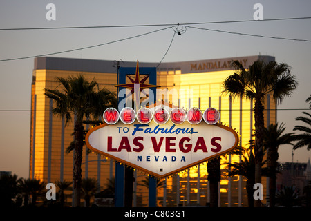 Benvenuto al favoloso cartello Las Vegas. Il Mandalay Bay Resort, luminoso e fuori fuoco al tramonto, mette in evidenza il famoso cartello. Clark County, Nevada, USA. Foto Stock