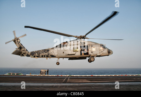 Un US Navy SH-60F Seahawk si libra sopra il ponte di volo della USS Eisenhower. Foto Stock